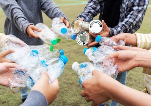 Woman Group Team Volunteer hand holding bottles garbage plastic Trash join empathy charity trust partner friendship. Volunteer team join hand at circle with bottles plastic Garbage waste at Park