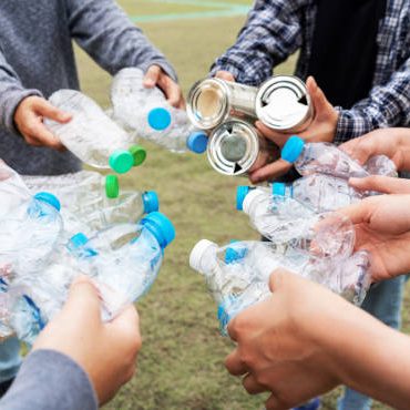 Woman Group Team Volunteer hand holding bottles garbage plastic Trash join empathy charity trust partner friendship. Volunteer team join hand at circle with bottles plastic Garbage waste at Park
